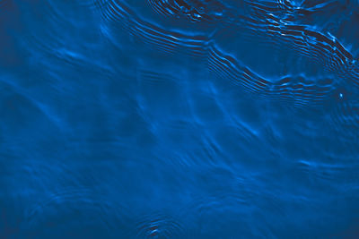 Transparent dark blue colored clear calm water surface texture