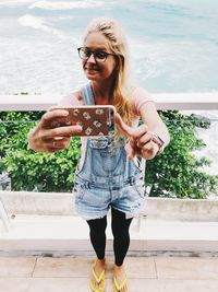 Full length of woman standing on mobile phone
