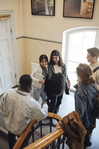 High angle view of multiracial students talking at staircase in university