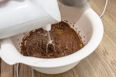 Mixing the dough with a hand mixer with a whisk with melted butter added, the dough is  thick mass.