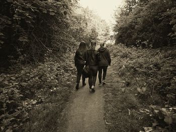 Rear view of people walking on footpath