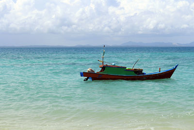 Fishing boat in sea against sky