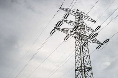 Low angle view of electricity pylon against sky