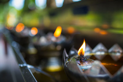 Close-up of lit candles against blurred background