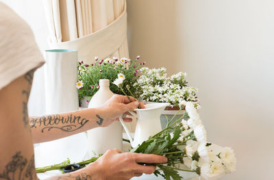 Midsection of flowers on table