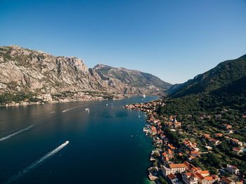 High angle view of townscape by mountains against clear blue sky