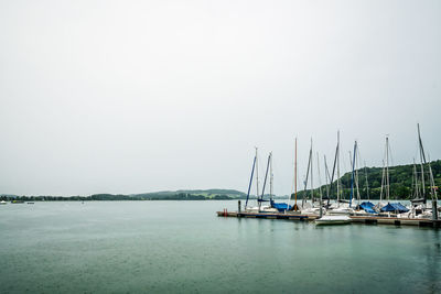 Boats moored in sea against clear sky