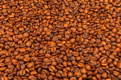 Full frame background and texture of roasted coffee beans on flat wooden surface