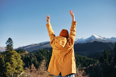 Rear view of man standing against mountain