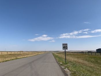 Road by field against sky