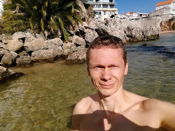 Portrait of shirtless man in sea