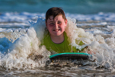 Happy boy playing in water at beach