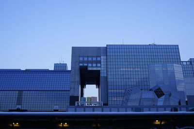 Low angle view of modern building against blue sky