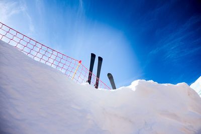 Low angle view of people on snowcapped mountain against sky