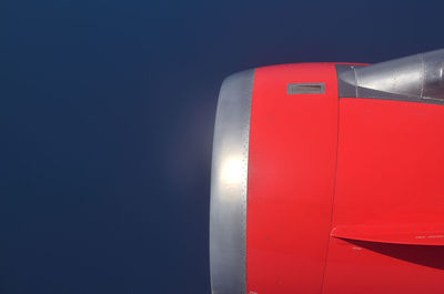 Close-up of red airplane against blue sky