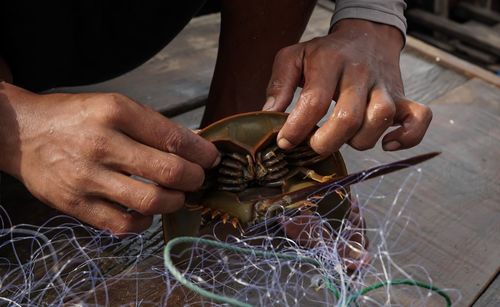 Midsection of man working on metal