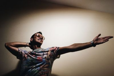 Smiling man dancing against wall