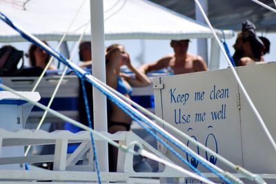 People on boat deck by information sign