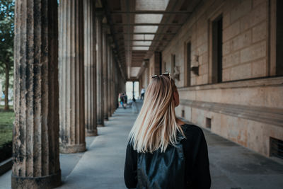 Rear view of woman standing in corridor of building