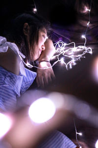 Digital composite image of woman with illuminated lights