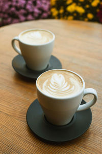 Close-up of two cappuccino cups on table