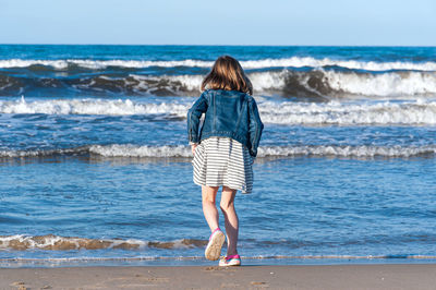 Rear view of woman standing on beach