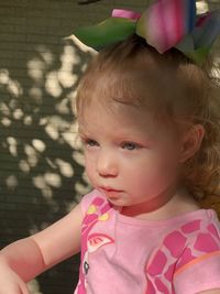 Close-up of cute girl sitting out outdoors