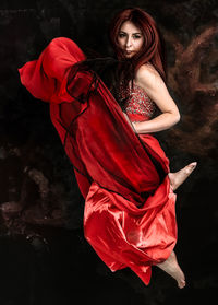 Portrait of beautiful young woman against black background