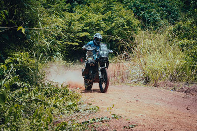 Professional enduro bike rider on action on sand terrain.