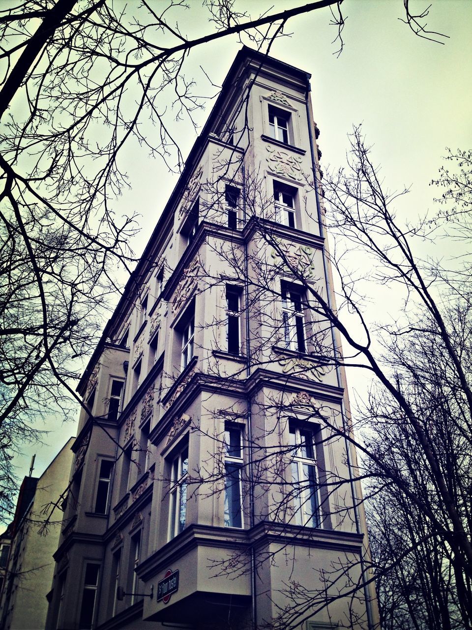 architecture, building exterior, built structure, low angle view, church, religion, place of worship, tower, bare tree, spirituality, clock tower, tree, branch, sky, city, cathedral, tall - high, clear sky