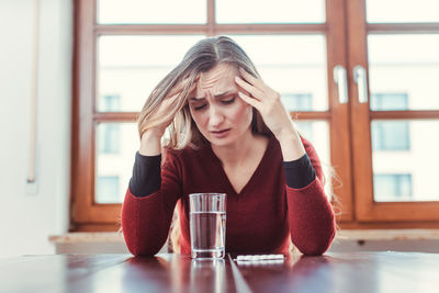 Portrait of young woman sitting on table