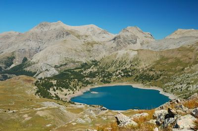 Scenic view of lake and mountains against blue sky