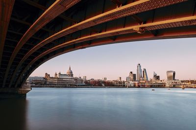 Arch bridge over river with buildings in background