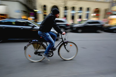 Blurred motion of people riding bicycle on road