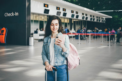 Portrait of young woman standing in city