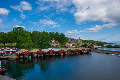 Houses by river and buildings against sky