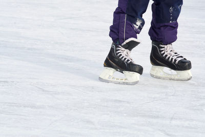 Low section of person ice-skating on ice rink during winter