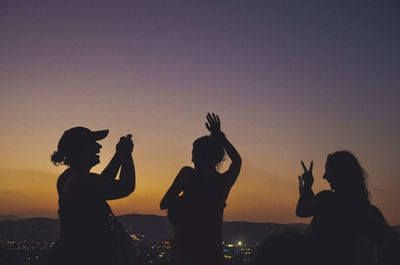 Silhouette people against sky during sunset