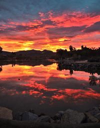 Scenic view of dramatic sky over lake during sunset