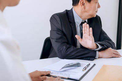 Businessman gesturing colleague in office