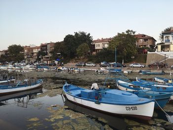 Boats moored in river against buildings in city