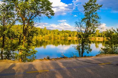 Scenic view of lake by trees against sky