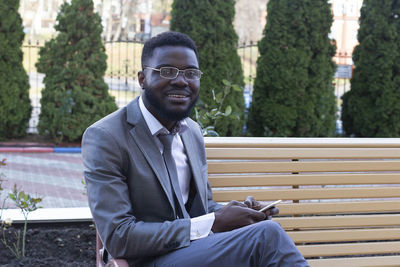 Portrait of young man sitting on bench