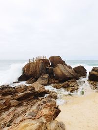 Rocks on beach against sky