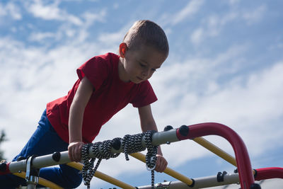 Child climbed the stairs in the playground and stands at the top. boy exercising outside