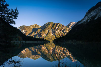 Scenic view of lake and mountains against clear sky