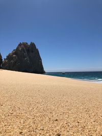 Scenic view of beach against clear blue sky