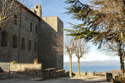 Exterior of historic building by sea against sky