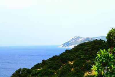 Scenic view of sea and mountains against clear sky