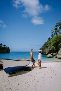 Men on beach against sky